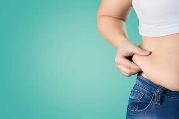 Image of woman pinching her love handles to show weight gain Amesbury